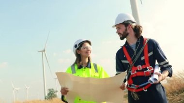 İki Kafkas teknisyeni rüzgar santralinin planlarını inceliyor, temiz ve çevre dostu bir enerji gücü olarak rüzgar türbinleriyle enerji üretiyorlar..