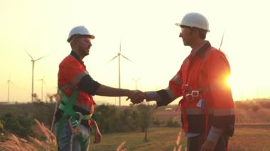 İki Kafkas teknisyeni rüzgar santralinin planlarını inceliyor, temiz ve çevre dostu bir enerji gücü olarak rüzgar türbinleriyle enerji üretiyorlar..