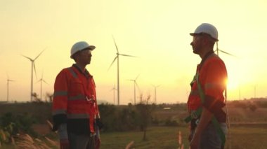 İki Kafkas teknisyeni rüzgar santralinin planlarını inceliyor, temiz ve çevre dostu bir enerji gücü olarak rüzgar türbinleriyle enerji üretiyorlar..