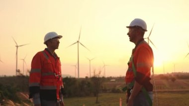 İki Kafkas teknisyeni rüzgar santralinin planlarını inceliyor, temiz ve çevre dostu bir enerji gücü olarak rüzgar türbinleriyle enerji üretiyorlar..