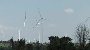 Teamwork two caucasian technicians inspect stands analyzing wind power station area blueprints, generating energy with wind turbines as a clean and environmentally friendly energy force.