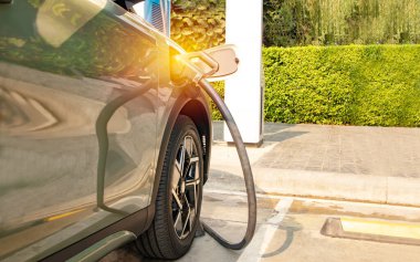 SUV elektrikli araba DC akımını akü prizine yüklüyor. Halka açık benzin istasyonundaki elektrikli aracı, temiz enerji araçlarını dolduruyor. Alternatif enerji popüler bir kavram haline geliyor.