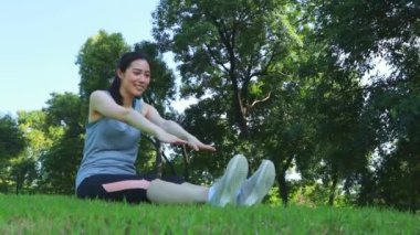 Genç bir kadın parkta kendini dengelemek için kaykay yapıyor, yavaşça güvenli bir yere yürüyor..