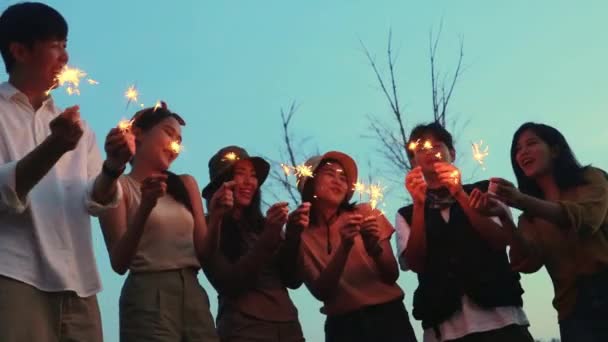 一群友善的亚洲男人和女人正在做文娱活动 欢快地歌唱 燃放焰火 点着美丽的火花 — 图库视频影像