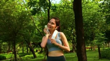 Parkta egzersiz yapan genç Asyalı kadın: Kişilik sağlığı, olumlu tutum, sağlık, spor psikoterapisi, neşeli ruh halini ısıtmak için egzersiz yapan kadın.