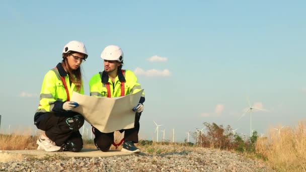 男性和女性研究人员或科学家检查可再生能源风力涡轮机塔建筑工地 以研究对环境和当地生物的影响 收集数据 — 图库视频影像