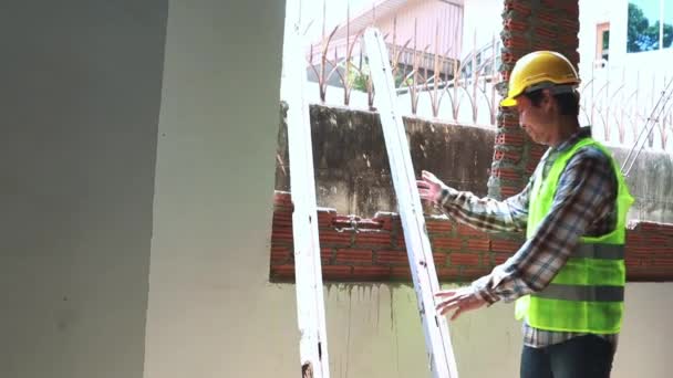 泰国工在大楼里干活 把硬木搬到水泥墙上 扛在肩上 来回走动 把建筑放在外面 — 图库视频影像
