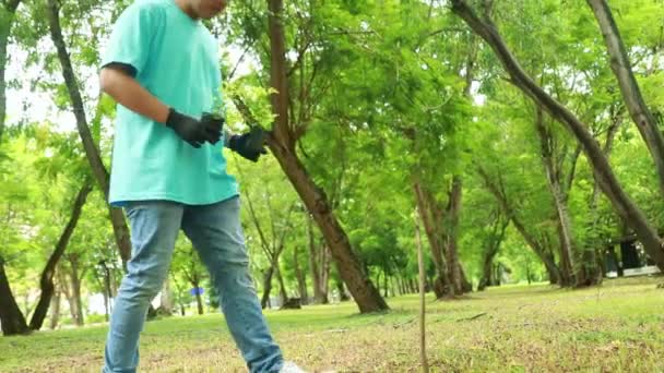 若いアジアの男性ボランティア 緑に日陰を追加する空きスペースの庭の環境を保存するために木を植える — ストック動画