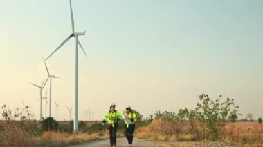 İki Kafkasyalı mühendis ve teknisyen rüzgar türbini istasyonundan çıkıyorlar. Rüzgar türbini enerji üretimi temiz ve çevre dostu..