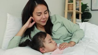 Asyalı anne ve oğul, kızlarıyla yatakta yatıyor anne ve oğlu yan yana uyuyor. Sevgi dolu bir sevgiyle, tatlı kızına sarılıyor ve onunla ilgileniyorlar..