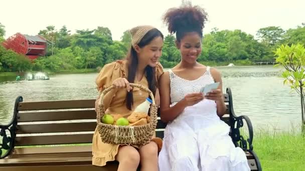 Милая Азиатка Держащая Корзину Фруктами Берёт Здоровую Беременную Африканскую Подругу — стоковое видео