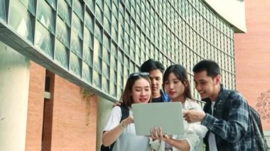 Asyalı erkek ve bayan üniversite öğrencilerini günlük kıyafetleriyle online öğretmenler, dizüstü bilgisayarlı sınavlar üniversite sınıfının önünde duruyor..