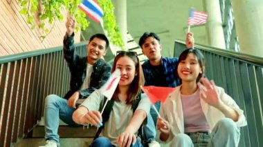 ABD, Çin, Japonya, Tayland gibi uluslararası bayrakları elinde tutan ve sallayan Asyalı üniversite öğrencileri: 21 Mart Uluslararası Irksal Ayrımcılığı ortadan kaldırma Günü.