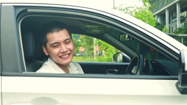 英俊潇洒的亚洲绅士驾驶汽车 带着他的会员保险卡 以确保顾客在开车时心平气和 并以保险单安全驾驶 — 图库视频影像