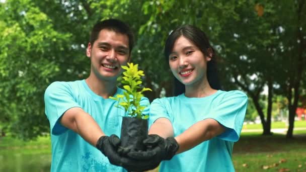 Asyalı Çift Çevre Ekoloji Gönüllüleri Fidanları Tutarak Kameraya Bakan Mutlu — Stok video