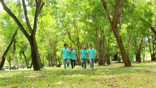 ハッピーグループの若いアジアの男性と女性は 環境ウォークを保存し 一緒に庭で抱き合って木を植えるために植物の木をボランティアしています — ストック動画