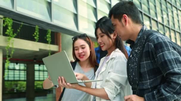 グループ アジアの男性と女性の大学生 カジュアルな服でオンラインのチューターを勉強 大学の教室の外に立っているノートパソコンとの試験 — ストック動画