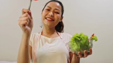 Sağlıklı ve yağsız bir öğle yemeği için besleyici dolmalık biber ve taze sebze yiyen genç Asyalı kadın: Sağlık hizmeti, yağ diyetini azaltma ve kilo verme.