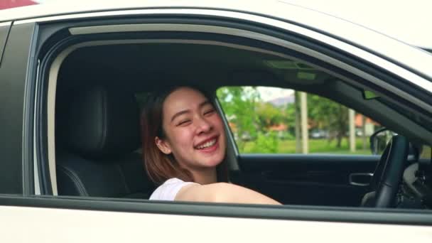 幸せな十代の女性の学生は 安全に運転し 大学で勉強した後に出発する準備ができて 窓によって快適に笑顔で座って運転に肯定的な感情を表現します — ストック動画