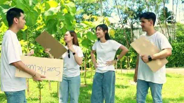 夏の暑さの中で緑の森林公園をきれいにするキャンペーンの準備をしている男性と女性の学生のボランティア — ストック動画
