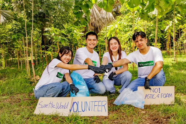 Portrait group asian men and women volunteers to protect the environment join hands unite together campaign against plastic waste or foam that causes pollution in forest planting activities.