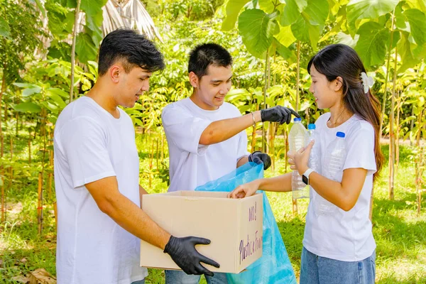 Working with voluntary youth volunteers doing good deeds for society : Volunteers Asian men and women collect plastic bottles left behind in the park and put them in boxes for recycling.