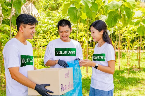 Working with voluntary youth volunteers doing good deeds for society : Volunteers Asian men and women collect plastic bottles left behind in the park and put them in boxes for recycling.
