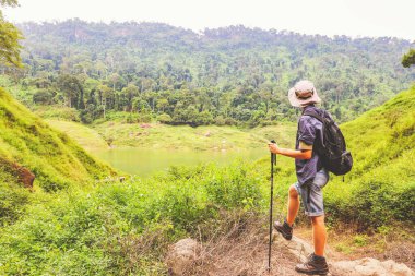 Genç beyaz erkek maceracı Tayland 'ın tropikal ormanlarında gezintiye çıktı. Gökyüzü dağlarına, nehirlere ve yemyeşil ormanlara baktı. Doğanın güzelliği ve temiz havası..