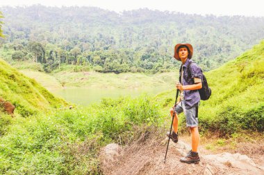 Genç beyaz erkek maceracı Tayland 'ın tropikal ormanlarında gezintiye çıktı. Gökyüzü dağlarına, nehirlere ve yemyeşil ormanlara baktı. Doğanın güzelliği ve temiz havası..