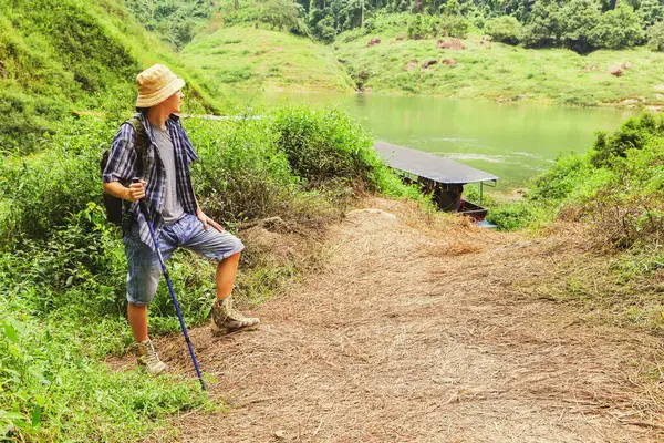 Genç beyaz maceraperest sırık tribünleri olan gezgin ve yolcu teknesinin turistleri gezintiye çıkarışını, doğa çalışmalarını, şelale dağlarını ve verimli nehirleri izledi..