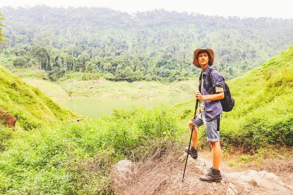 Genç beyaz erkek maceracı Tayland 'ın tropikal ormanlarında gezintiye çıktı. Gökyüzü dağlarına, nehirlere ve yemyeşil ormanlara baktı. Doğanın güzelliği ve temiz havası..