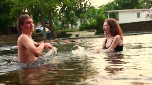 快乐浪漫的夫妻在大自然的夏天旅行 呆在一个快乐的度假胜地 在清凉的河里玩耍 站在那里拥抱对方 彼此是最快乐的 — 图库视频影像