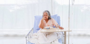 Yaşlı Asyalı kadın, mide iltihabı, gastrointestinal hastalık, hastaneye yatırılmış, tatsız lapa yemekten yorulmuş, iştahı yok. Yemek istemiyorum, kendimi toparlamaktan yoruldum..