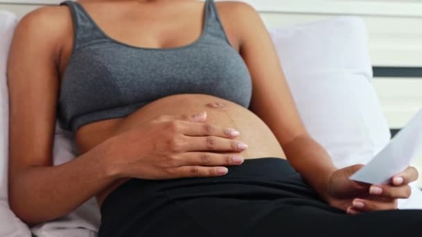 Schwangere Afroamerikanische Mutter Sitzt Auf Betthänden Und Streichelt Sanft Ihren — Stockvideo