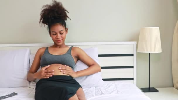 Gravid Afrikansk Amerikansk Mamma Sitter Sängen Tittar Sitt Barn Försiktigt — Stockvideo