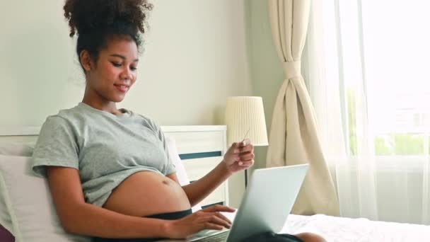 アフリカ系の妊娠中の若い母親は 殺菌された牛乳を飲む準備をしている彼女の寝室に座っていますが 彼女はそれを飲むことができない悪臭で病気です 妊娠中の女性のためのヘルスケアの概念 — ストック動画