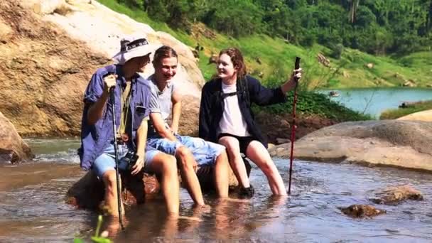 Группа Мужчин Женщин Туристические Друзья Пешие Прогулки Сидя Водопаде Поток — стоковое видео