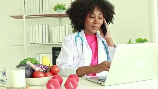 Афро Американская Женщина Диетолог Сидя Печатая Медицинские Работы Клавиатуре Разговаривая — стоковое видео