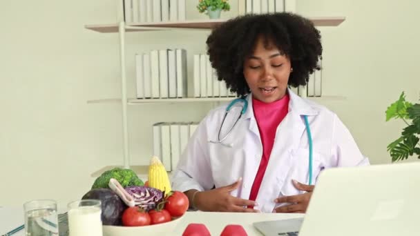Afroamerykanka Kobieta Dietetyk Siedzi Pisząc Prace Zdrowotne Klawiaturze Rozmawiając Smartfon — Wideo stockowe