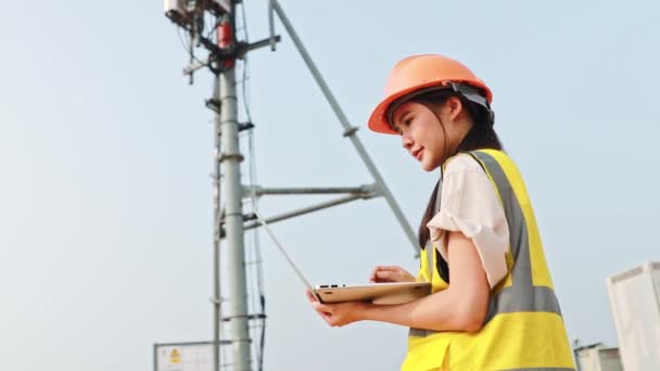 Ασιάτισσα Γυναίκα Μηχανικός Φορώντας Κράνος Εκτελεί Εργασίες Πεδίου Τηλεπικοινωνιακό Πύργο — Αρχείο Βίντεο