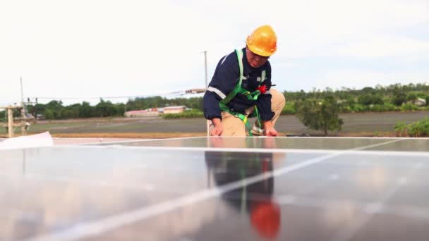 アジアの男性電気技師エンジニアは 各ソーラーパネルが品質検査を通じて親指を与える重要な点をチェックする工業工場の金属屋根にソーラーパネルの設置を検査します — ストック動画