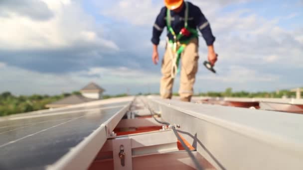 模糊的亚洲男性电气工程师检查太阳能电池板安装钢结构屋面工厂在屋顶附近走来走去举行电钻检查每个太阳能电池板的要点 — 图库视频影像