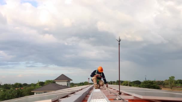 亚洲男性电工工程师检查金属屋顶工厂安装太阳能电池板时 手持电钻走来走去 检查剪贴板上每个太阳能电池板的重要位置 — 图库视频影像