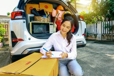 Başarılı bir işi olan Asyalı güzel bir iş kadını elinde bavulla taşınmaya hazırlanıyor. Parlak gülüşü olan eşyaların listesi. Yeni bir ev ile yeniden yerleştirme başlıyor..