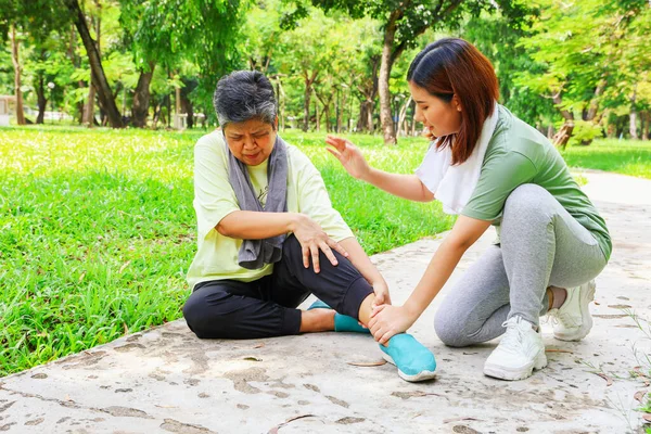 정원에서 스포츠를 그녀의 발목에 통증을 그녀의 딸에서 처치를 그녀의 통증을 스톡 사진