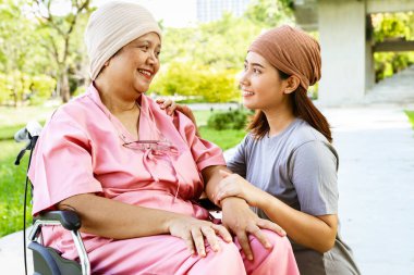 Kanserli baş örtüsü takan yaşlı annenin portresi, tekerlekli sandalyede oturan ve başörtüsü takan sevimli kızıyla birlikte oturan annesine sevgiyle sarılan annesinin ona mutluluklar dilemesi için onu cesaretlendiriyor..