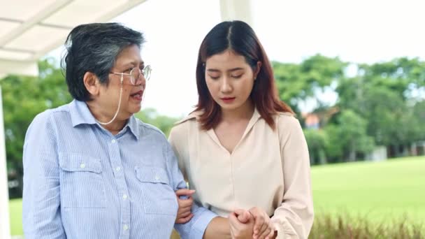 母と娘は成長し 手を携えて庭をゆっくり歩き 高齢者の健康を大切にし 家族関係を強化する — ストック動画