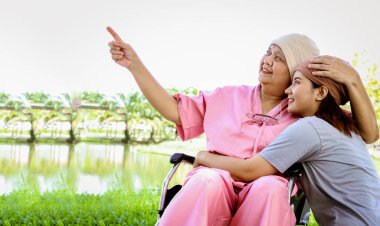 Kanserli neşeli yaşlı anne başörtüsü takıyor. Bebek arabasıyla gökyüzüne bakıyor. Sevgi ve sevgiyle sarılıyor..