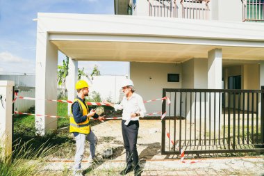 İnşaat uyarısı sırasında kazaları azaltmak amacıyla dikkatli bir şekilde tehlikeyi önlemek amacıyla, inşaat projesinde çalışan işçiler ve güvenlik görevlileriyle yapılan görüşmeler girişleri engelliyor.