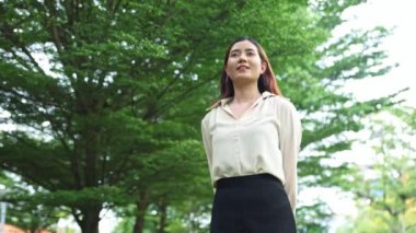Sağlıklı genç Asyalı kadın ayakta duran ve ozonu kucaklayan temiz hava güzel esinti güzel yeşil ağaçlar parkta güzel hava iyi akıl sağlığı.